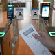 Person holding a boarding pass approaches facial recognition kiosk at the Hamburg, Germany, Airport.